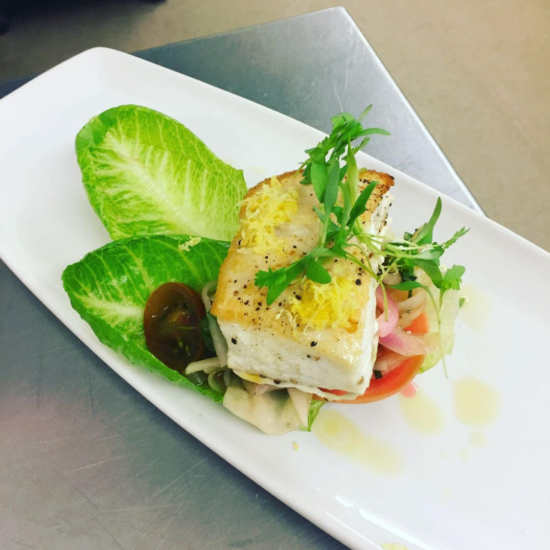 A pristine white plate featuring a delectable fish dish, artfully arranged for an appealing presentation. A pristine white plate featuring a delectable fish dish, artfully arranged for an appealing presentation.