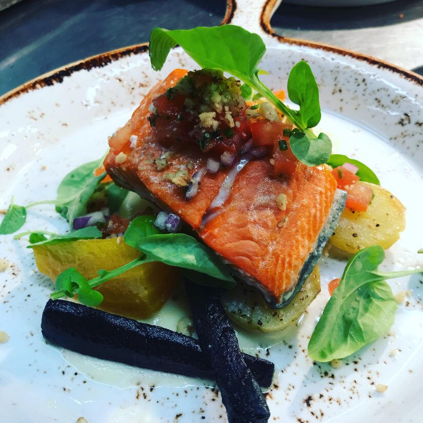 A dish showcasing a grilled fish served alongside a vibrant mix of seasonal vegetables on a white plate. A dish showcasing a grilled fish served alongside a vibrant mix of seasonal vegetables on a white plate.