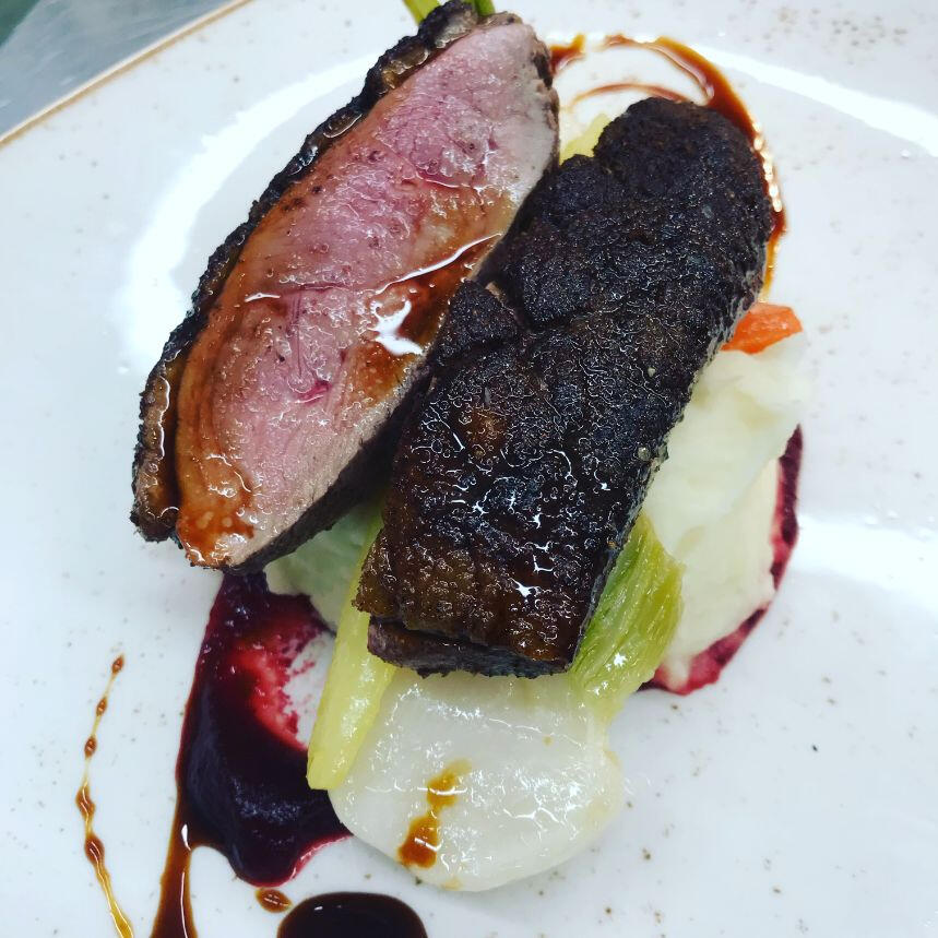 A succulent piece of meat garnished with sauce, elegantly presented on a white plate. A succulent piece of meat garnished with sauce, elegantly presented on a white plate.