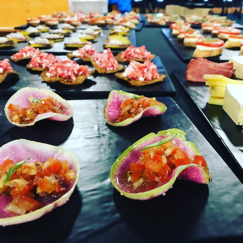 A table displaying an assortment of appetizers elegantly arranged on sleek black trays. A table displaying an assortment of appetizers elegantly arranged on sleek black trays.